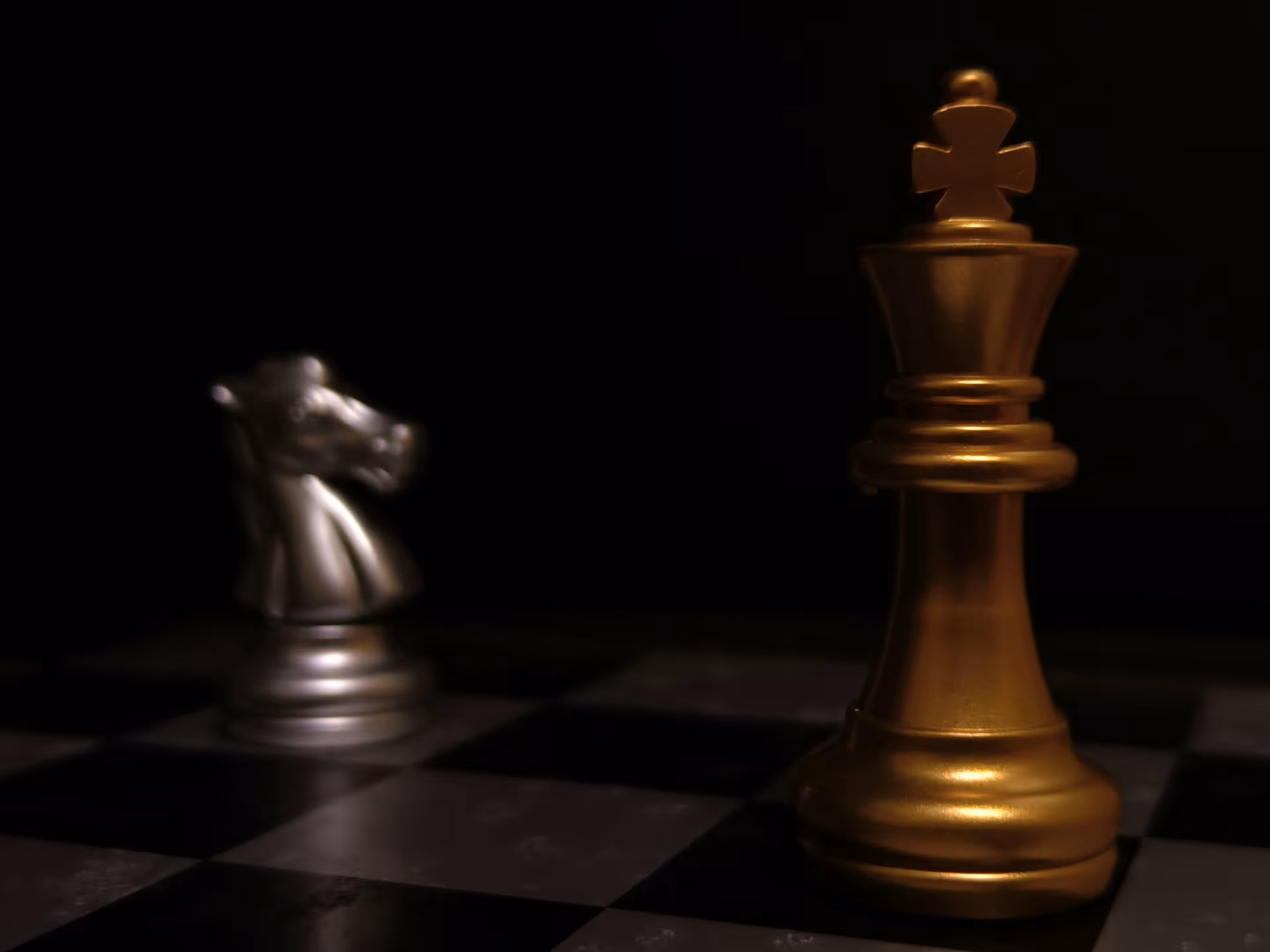 Golden chess king piece with a white knight on a chessboard